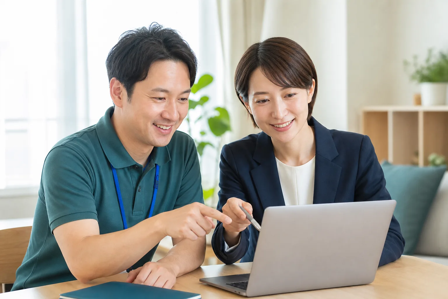 施設の管理者と伴走スタッフが1台のノートパソコンの画面を一緒に確認している様子